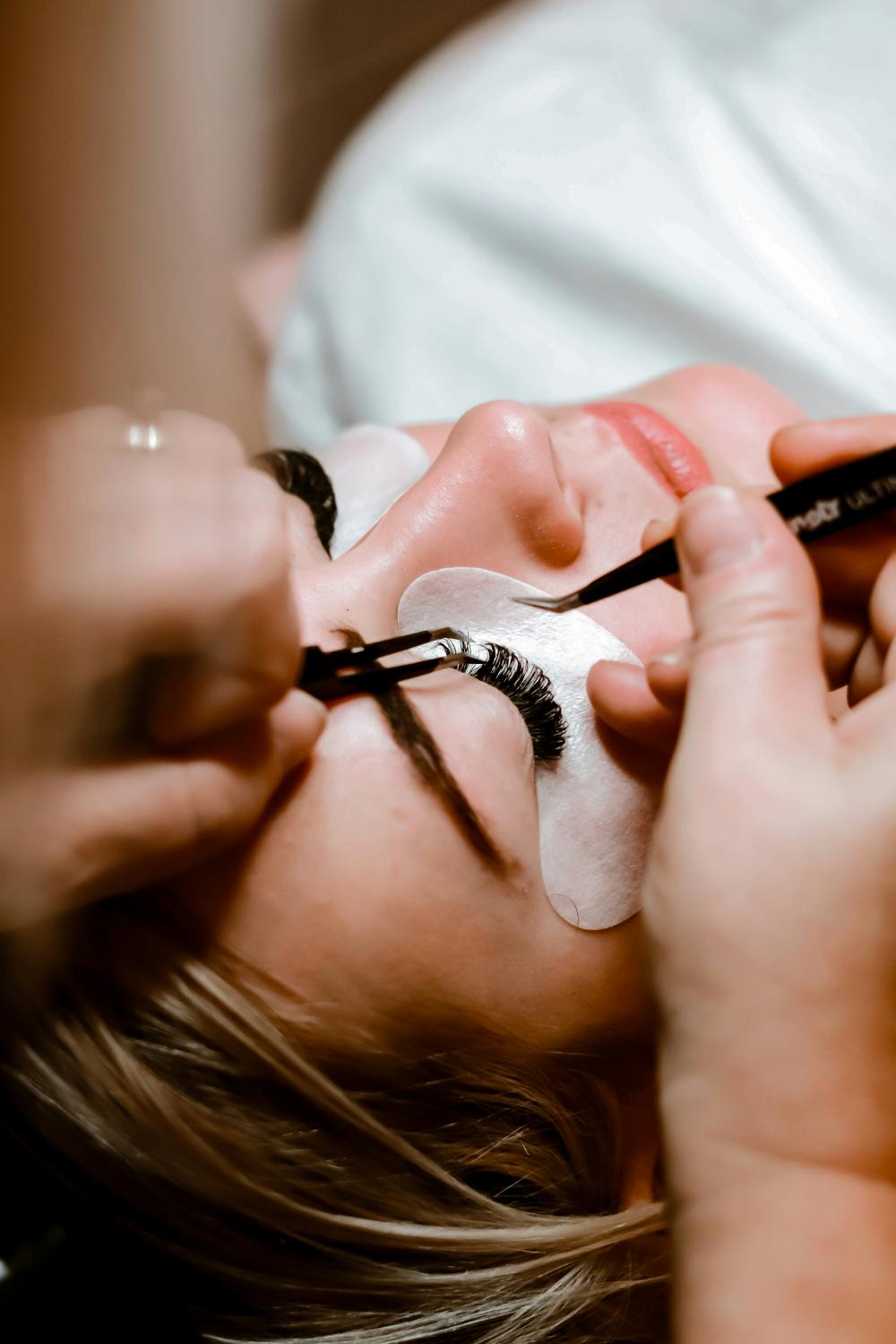 professional lash technician meticulously applying eyelash extensions on a client