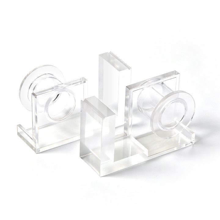 Clear acrylic lash tape dispenser with a pink tape roll and a built-in cutting edge, shown on a white background.